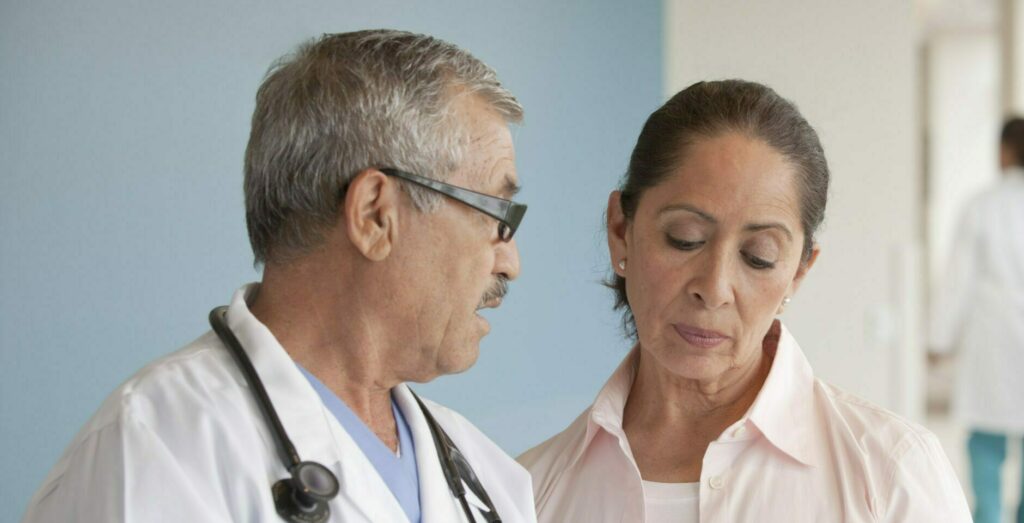 Doctors talking to woman in hospital